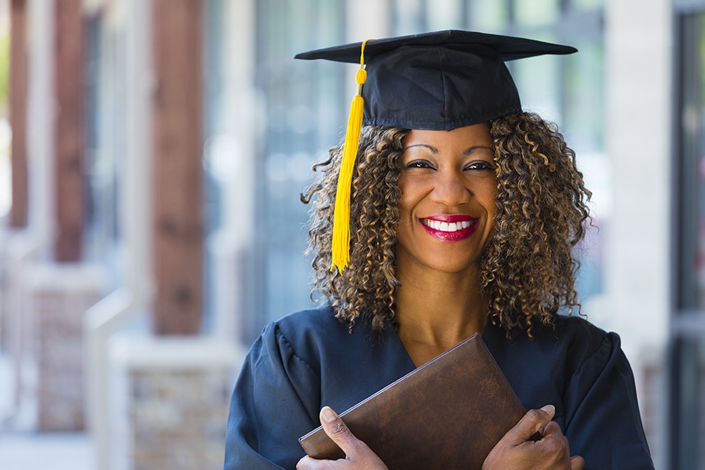 Happy Graduate a woman in a graduation cap and gown holding a diploma