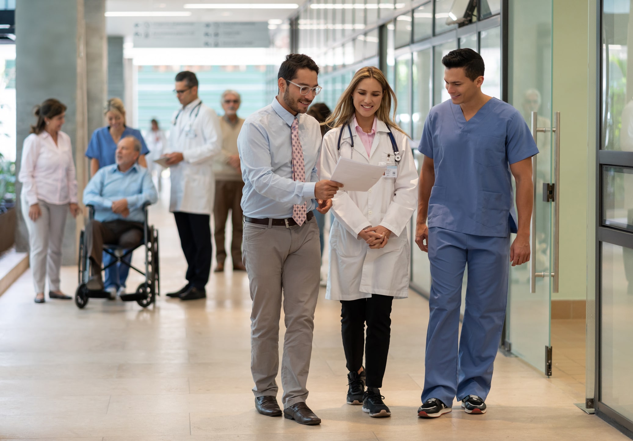 Hospital manager showing a document to doctor and nurse all smiling