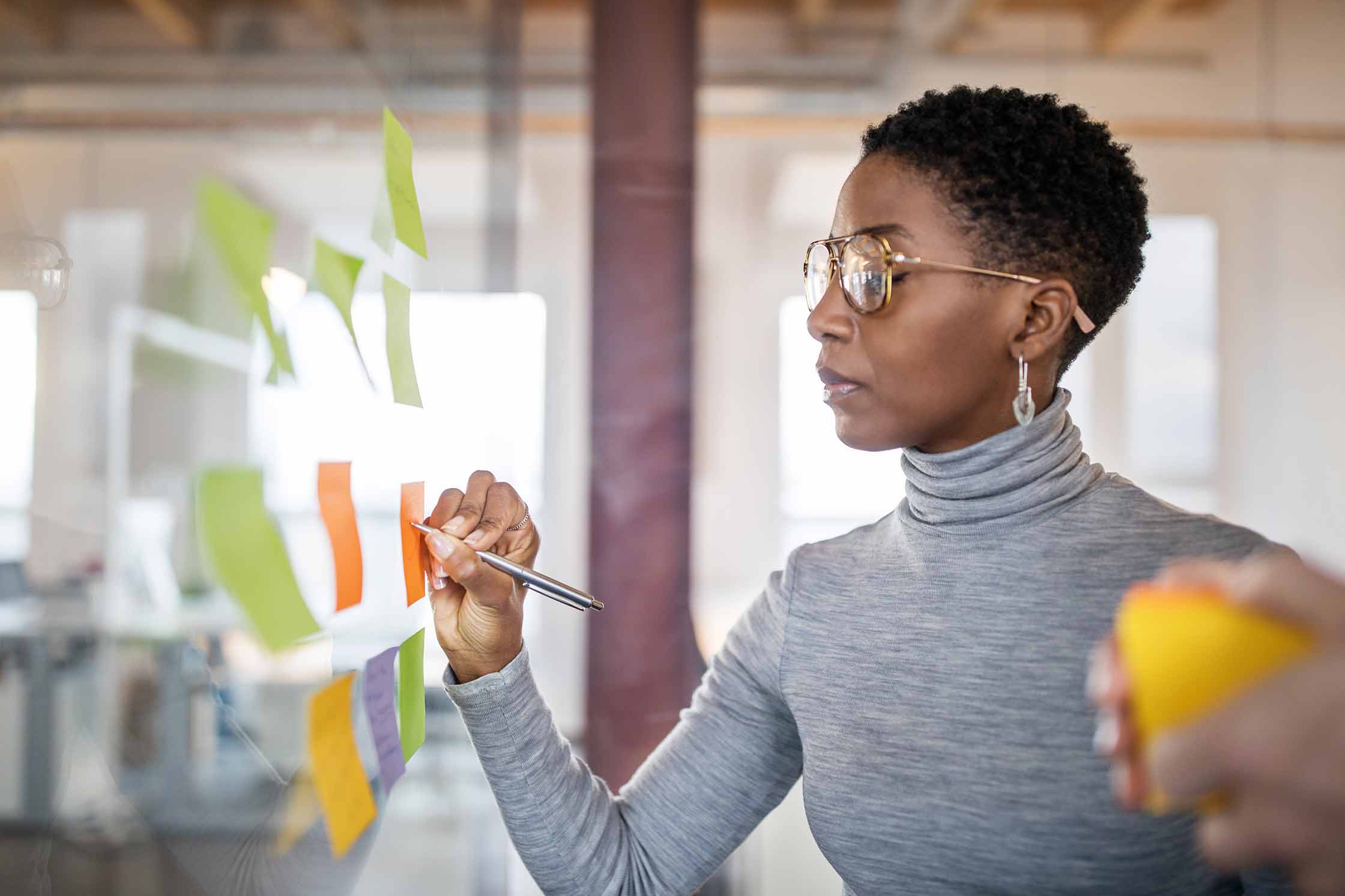 MOL-Prof_stud a woman observing a wall of sticky notes