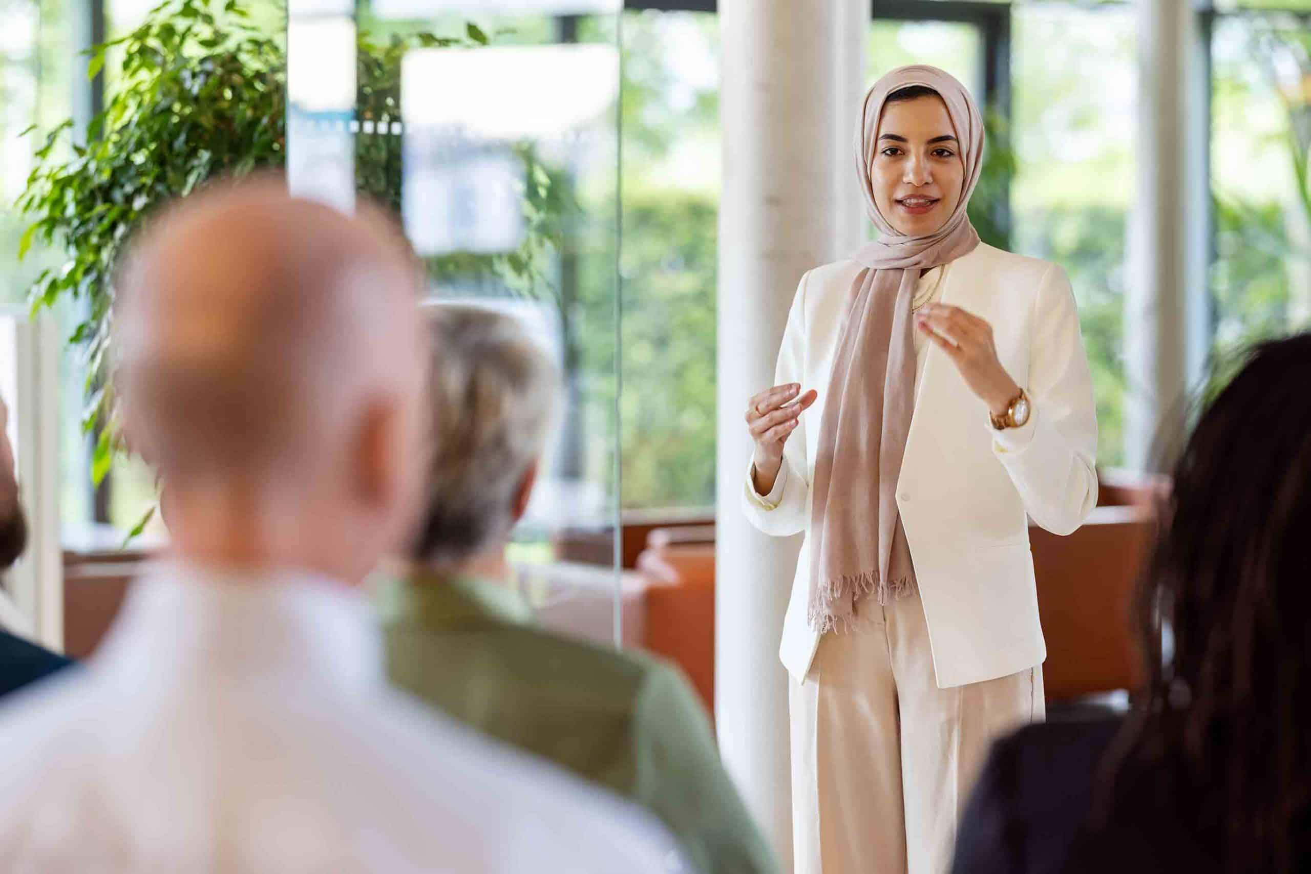GettyImages-1341307405 a woman instructing and leading a group of seated individuals