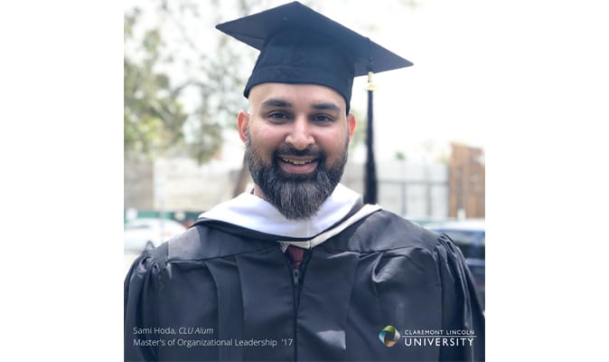 a man standing outside in a graduation cap and gown